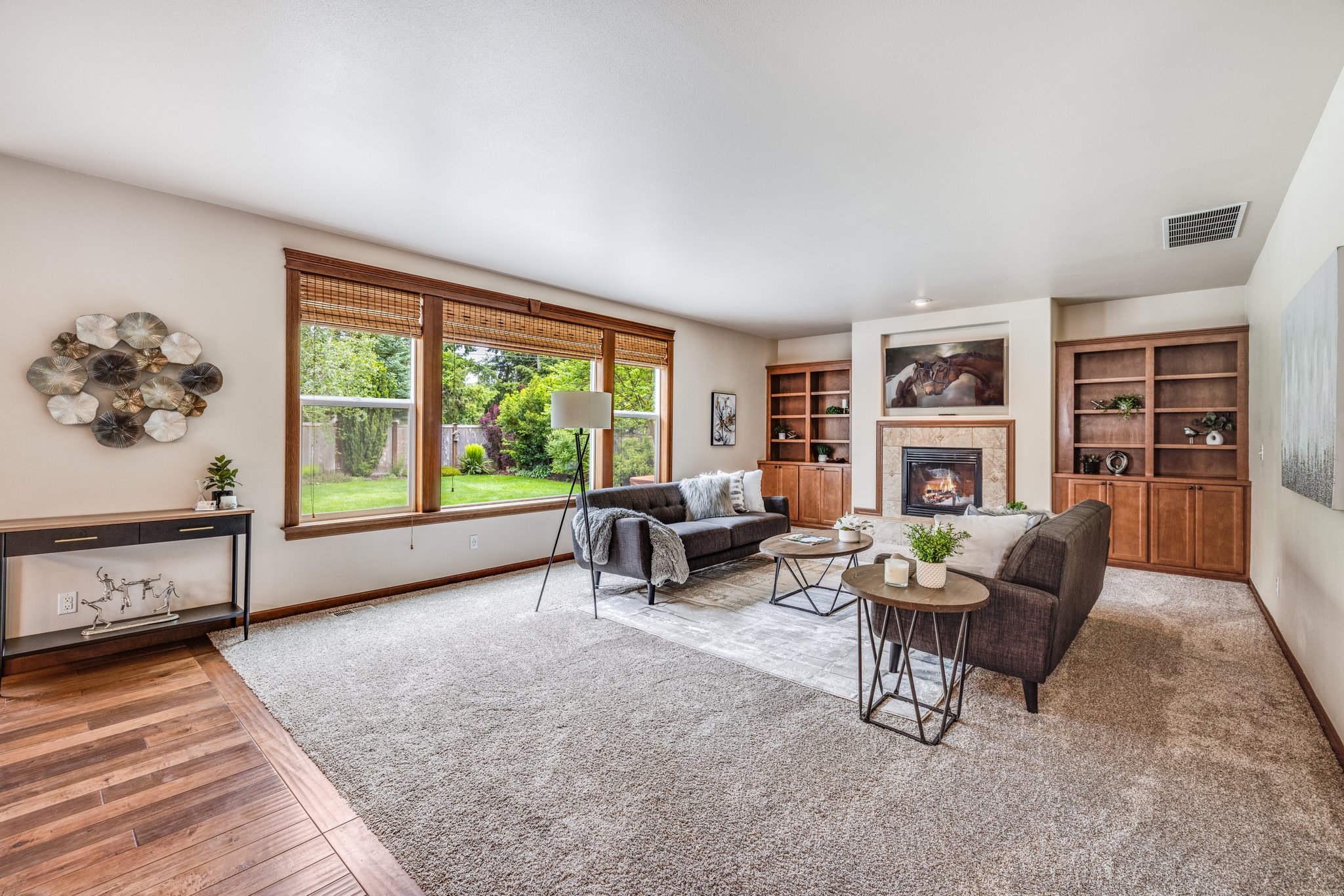 Large living room has gas fireplace & custom bookshelves with cabinets