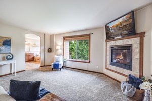 Large window and gas fireplace make the primary a cozy space