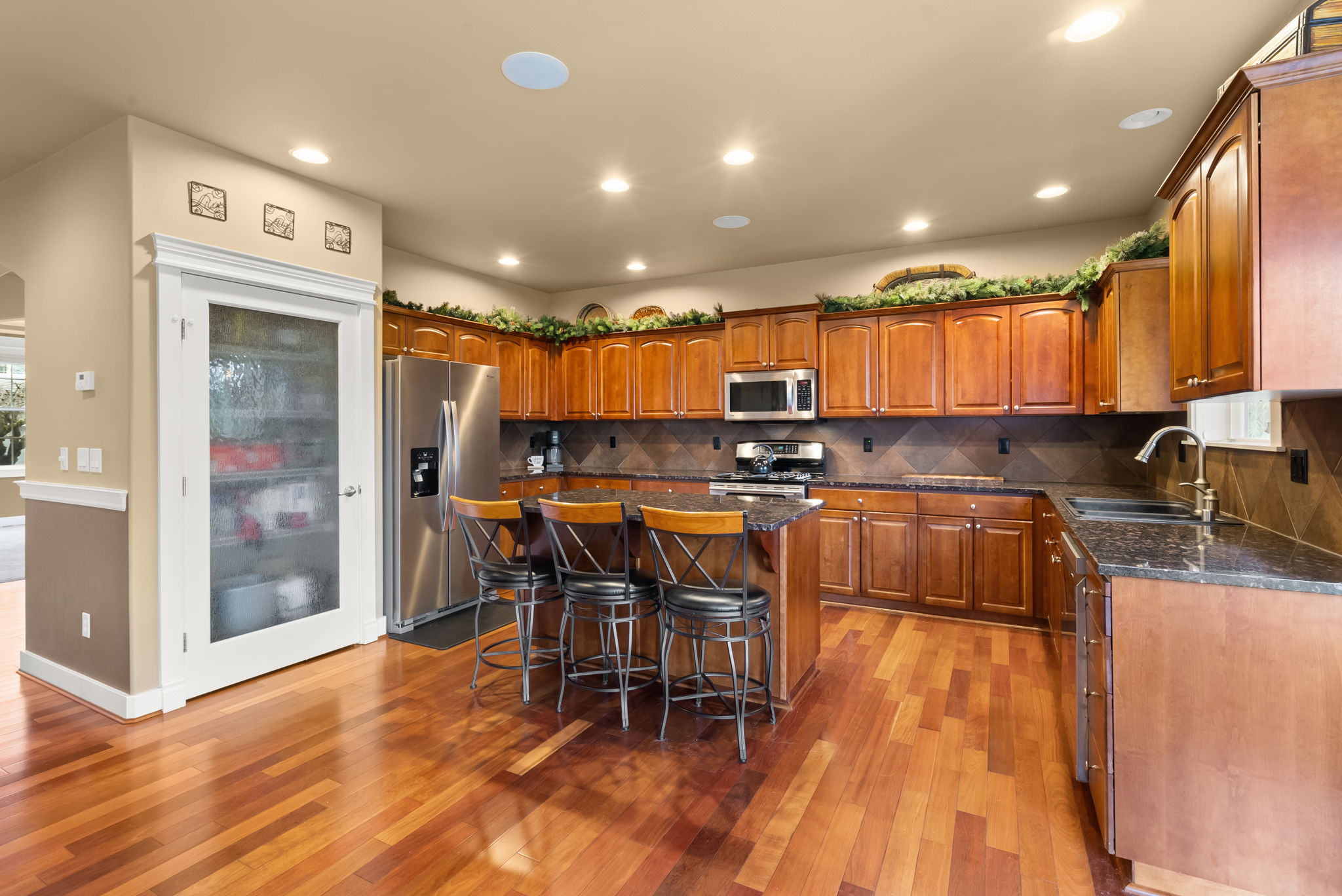 Spacious kitchen featuring generous cabinet storage, pantry, and island seating.
