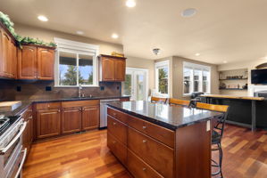 Open-concept kitchen: culinary creativity meets comfortable living. Flows into the second living area, ideal for gatherings. Offers an unparalleled connection to the outdoors with breathtaking backyard views.