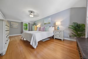 A spacious primary retreat with room to truly exhale - soft light, warm hardwood floors, and peaceful treetop views create the kind of calm that makes the end of the day feel especially good.