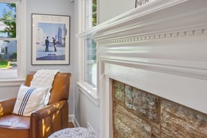 One of the loveliest details in this home is the unexpected dentil molding, shown here surrounding the stone fireplace - a traditional architectural flourish woven into a more relaxed mid-century layout.