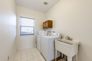 Separate area for laundry with cabinets and a sink!
