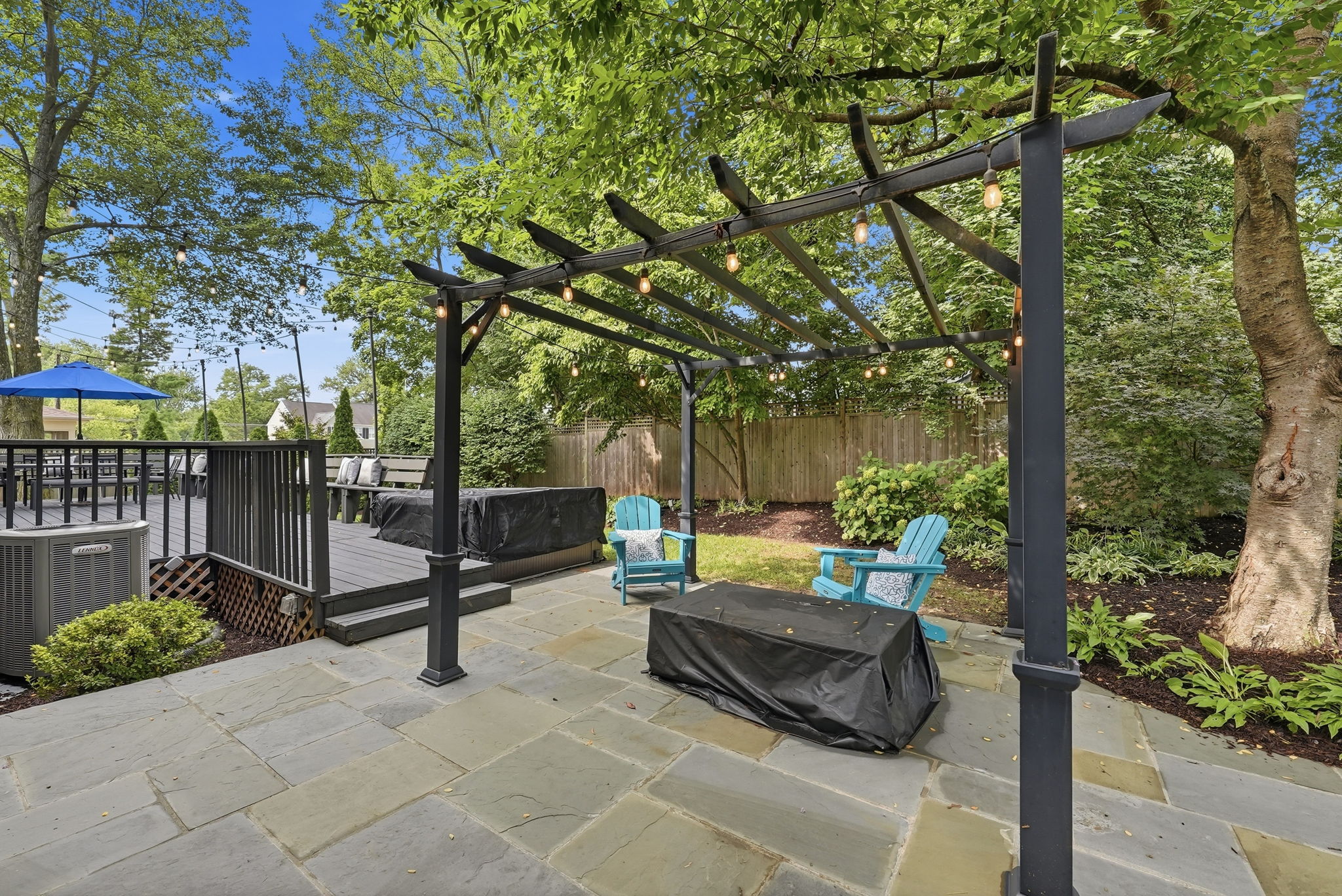 Stone patio with fire pit, pergola and hot tub