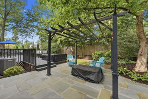 Stone patio with fire pit, pergola and hot tub