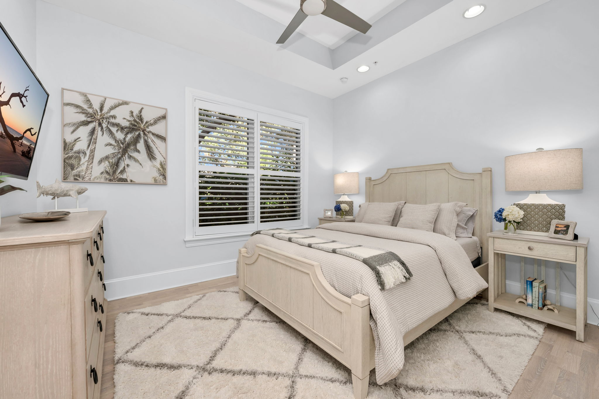 Guest bedroom with plantation shutters, new wood plank flooring, and a large walk in closet.