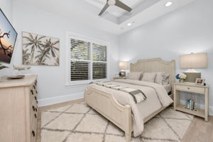 Guest bedroom with plantation shutters, new wood plank flooring, and a large walk in closet.