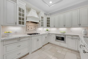 Large kitchen with granite countertops, Jenn-Aire appliances, and gas range.