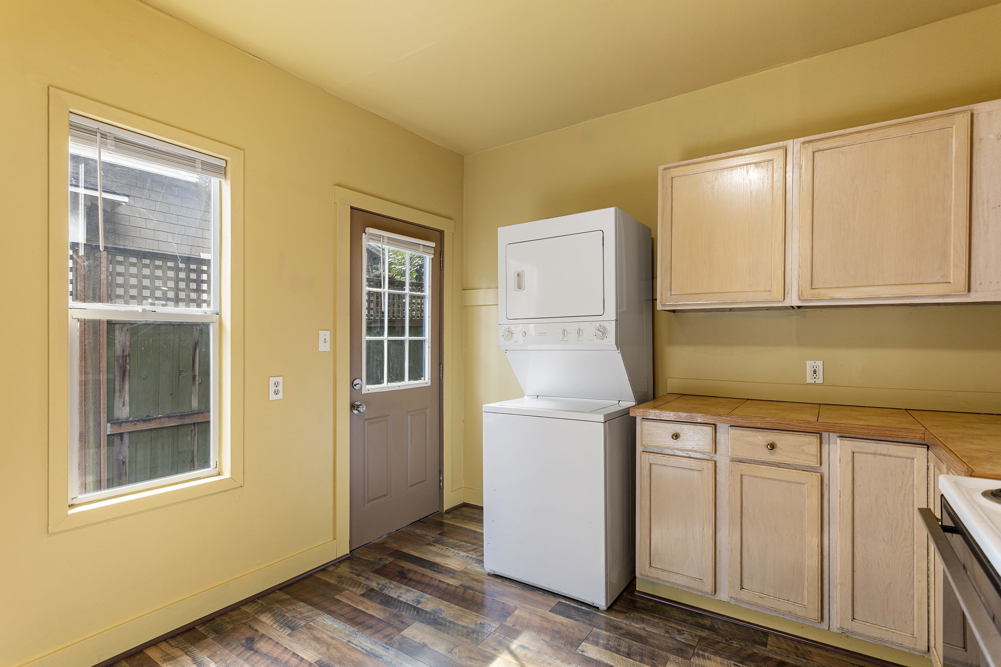 East-facing kitchen catches the morning light, with in-unit laundry and a separate door directly to the backyard.