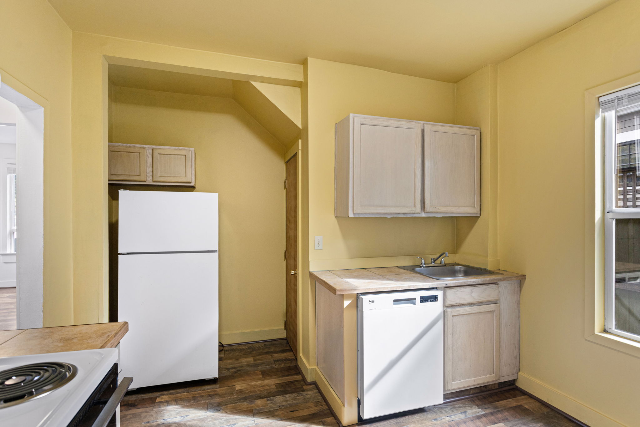 A walk-in pantry/storage closet just beyond the refrigerator adds substantial kitchen storage.