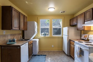 The upper kitchen keeps in-unit laundry tucked beside the sink.