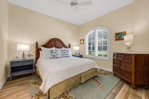 The front ensuite guest bedroom is bright and cheery with wood floors.