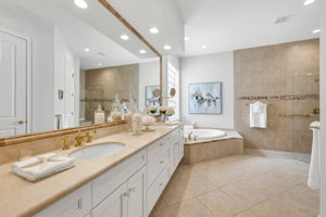 The Primary bathroom has a soaking tub and frameless-door shower with recently painted cabinets.