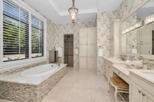 The primary bath has had custom storage cabinets added, with a large, walk-in shower.