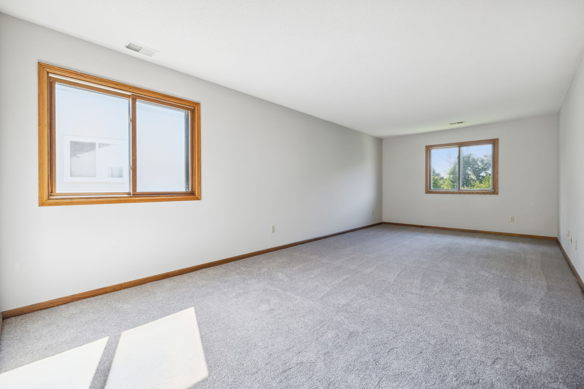 The Primary bedroom is very spacious with 2 large windows with treetop views