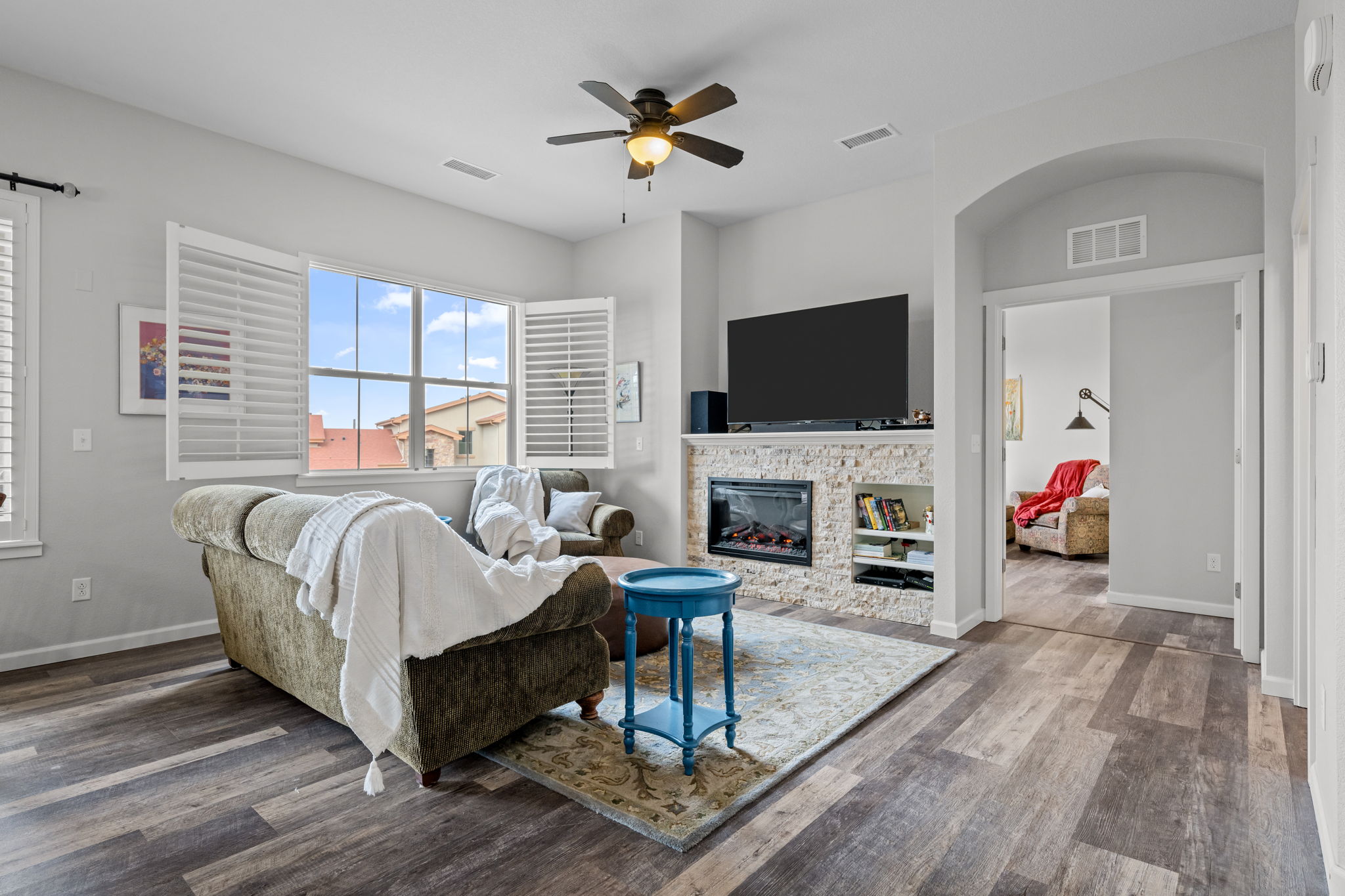 Living Room with view out large window, plantation shutters, ceiling fan