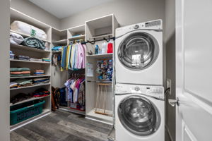 Custom cabinetry in walk in closet with stackable washer & dryer (included)