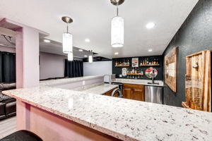 Basement bar area with granite countertops. Plenty of seating for fun with friends!