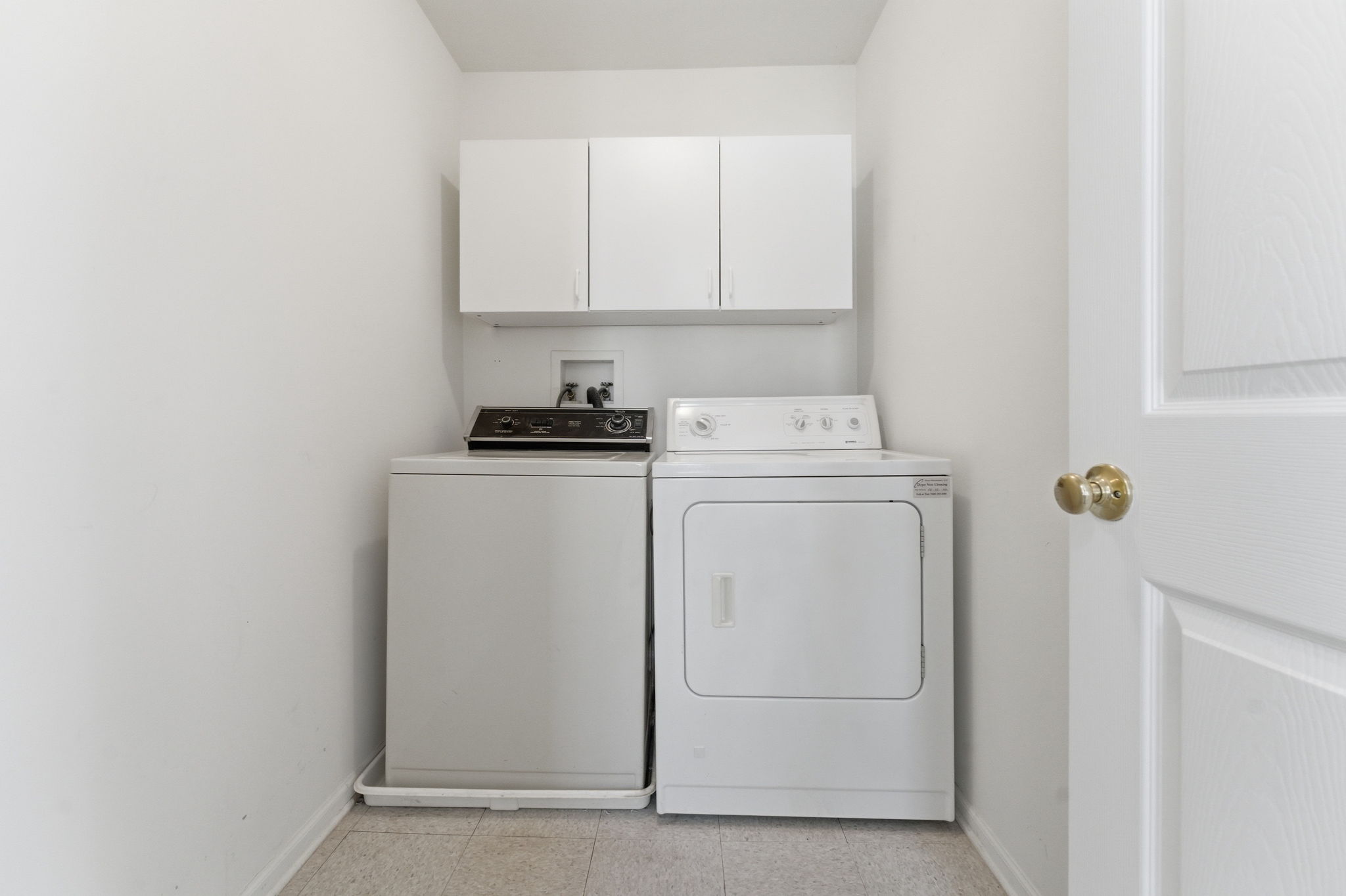 Convenient laundry closet with cabinetry, washer and dryer.