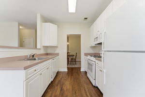 Crisp white cabinetry and white GE appliances. Recessed lighting, ceiling fan and refinished hardwood floor.