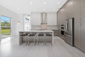Kitchen - Ceiling-height cabinet and pantry doors with hardwood inserts and under-mounted rails