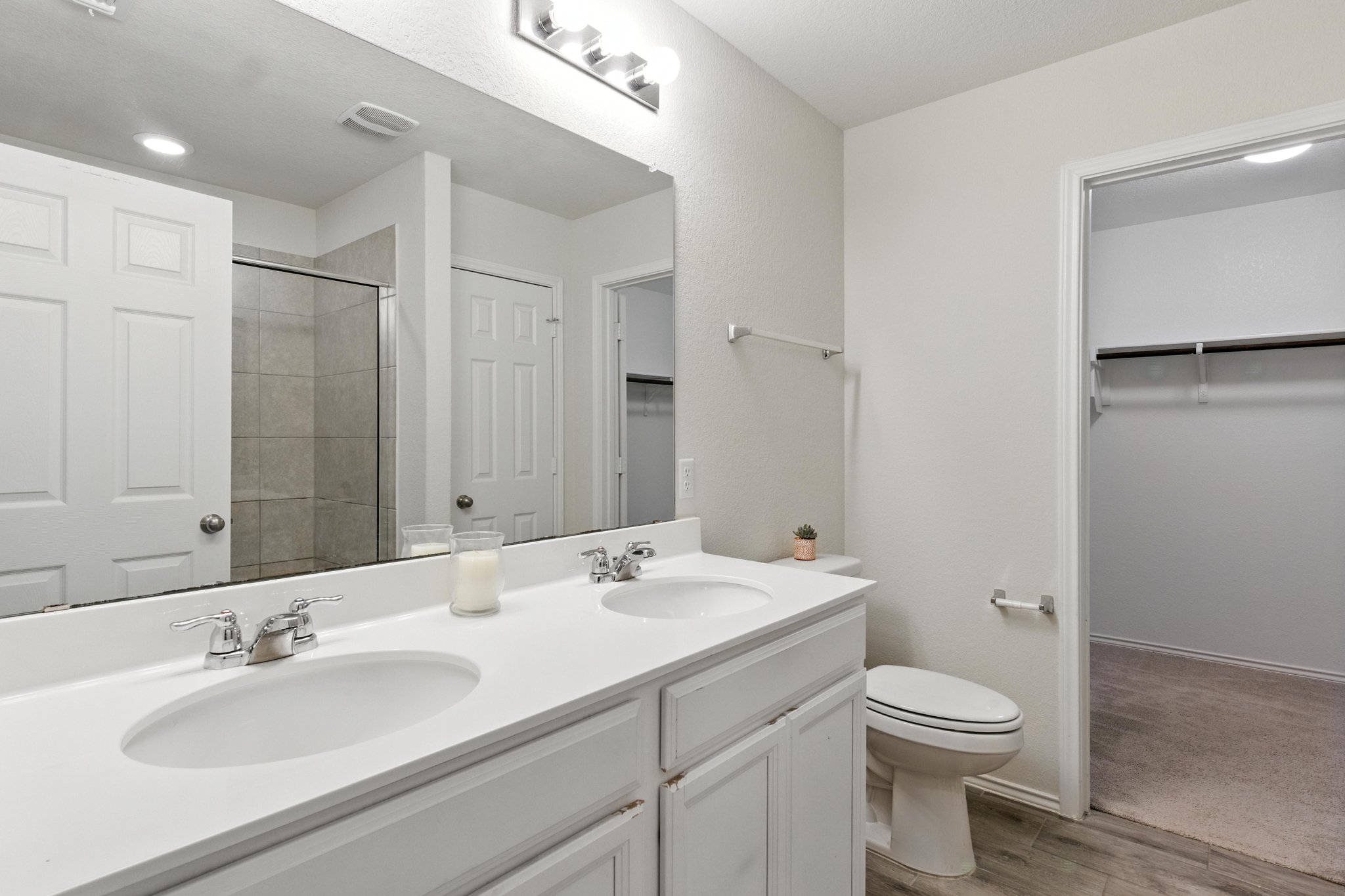 The lavish owner's suite features double vanities and cabinets and a linen closet for ample storage.
