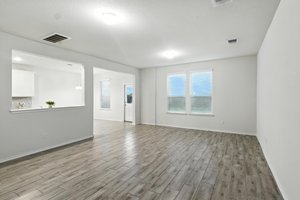 The spacious family room features beautiful wood look tile floors and a wall of windows for plenty of natural light.