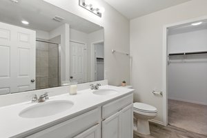 The lavish owner's suite features double vanities and cabinets and a linen closet for ample storage.