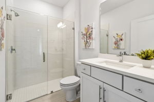 ...as is the guest bath, with sleek frameless shower doors.