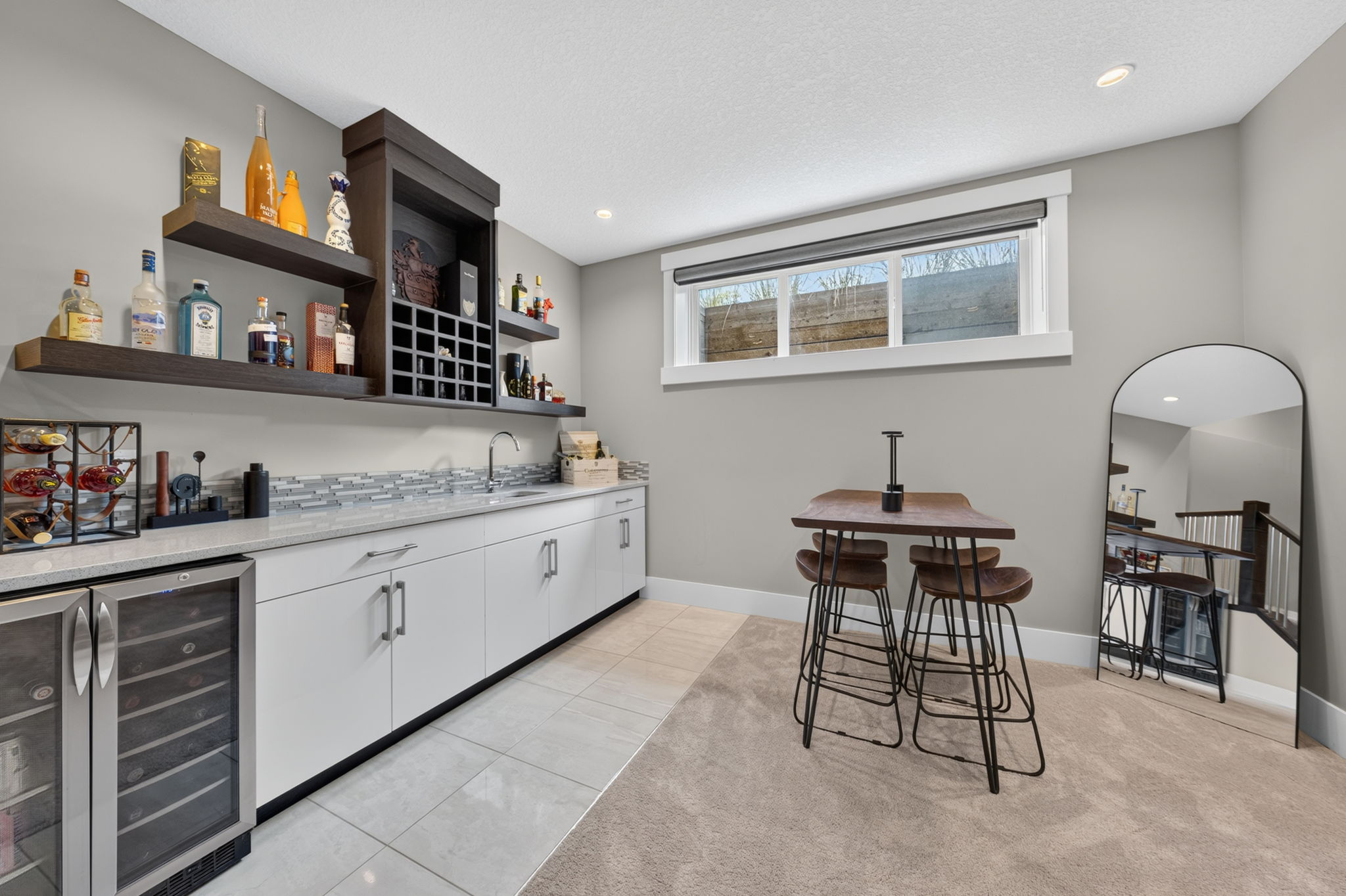 Lower-level wet bar with beverage fridges and counter seating
