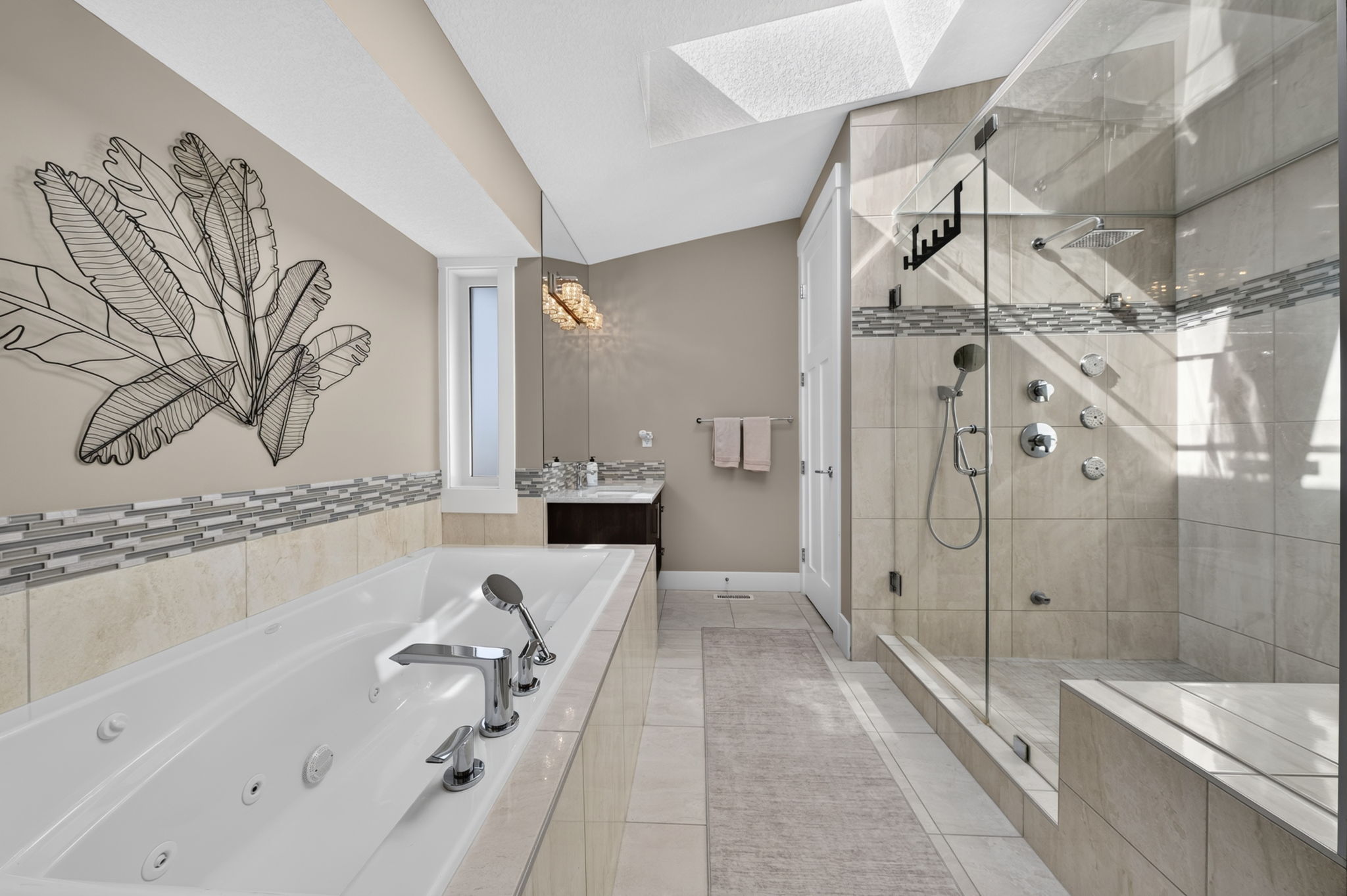Spa ensuite with soaker tub, skylight and glass shower