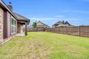 This expansive irrigated yard with wooden privacy fence is ready for personalization
