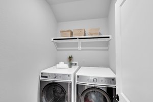 A downstairs laundry room is strategically located and offers ample space for all laundry needs