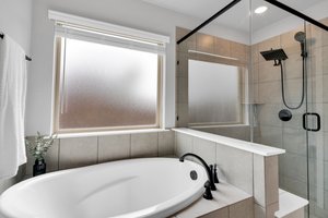 This spa retreat includes both tub and glass-enclosed shower with rain shower head and seat