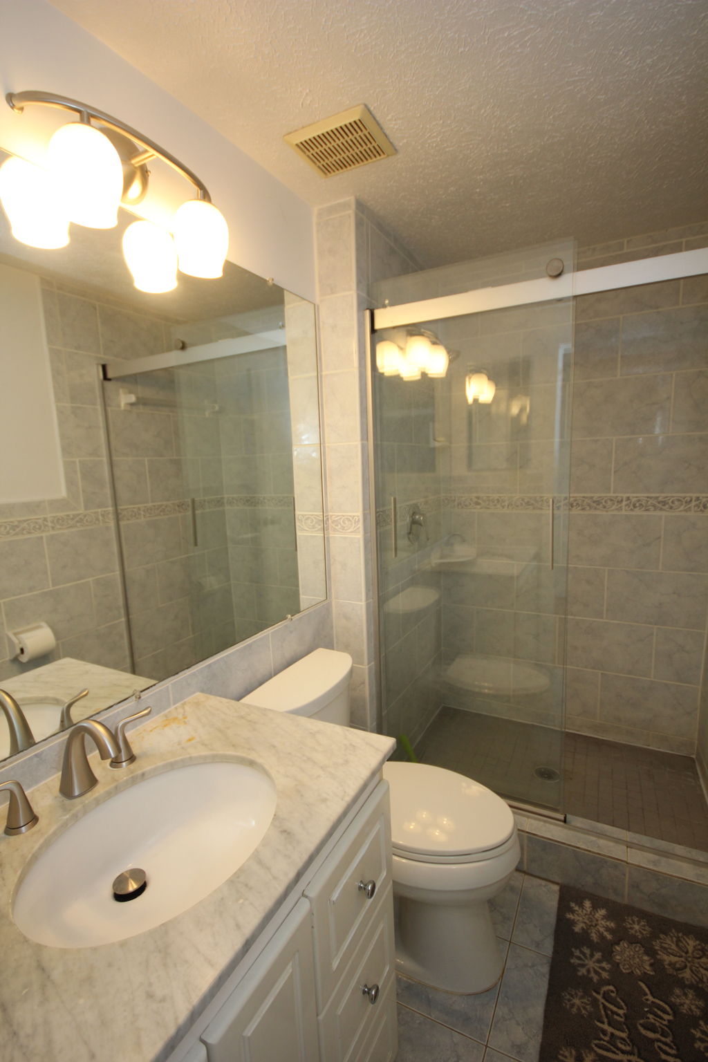 Updated primary suite bath w/hanging glass doors