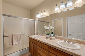 Primary en-suite bathroom with dual sink vanity and second walk-in closet.