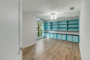 A large guest room showcases custom built-ins and a grand arched window.