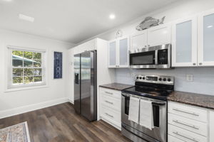 Granite countertops * Glass tile backsplash - Newer stainless steel refrigerator, dishwasher & microwave