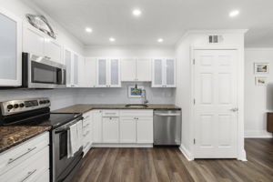 Granite countertops * Glass tile backsplash - Newer stainless steel refrigerator, dishwasher & microwave