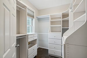 walk in closet is complete with closet organizing system