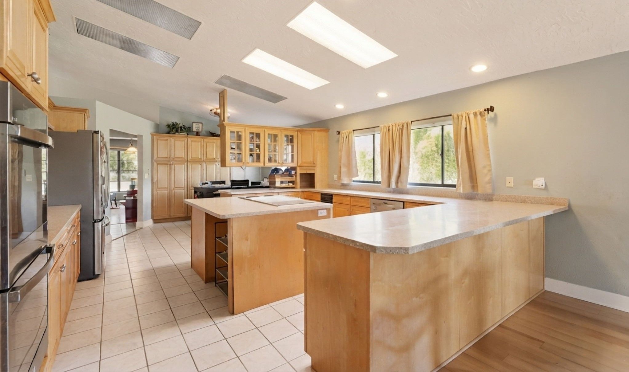 Enormous kitchen featuring double ovens, bar seating, abundant cabinetry and countertop space, and cooking island!