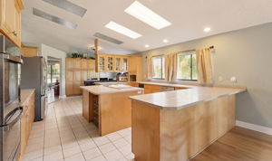 Enormous kitchen featuring double ovens, bar seating, abundant cabinetry and countertop space, and cooking island!