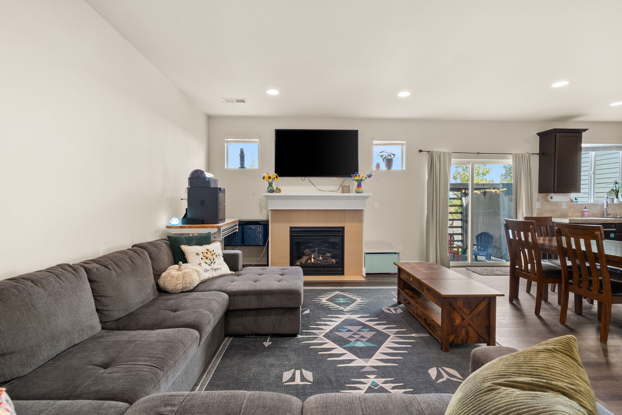 Spacious living room with gas fireplace and an open connection to the dining and kitchen areas.