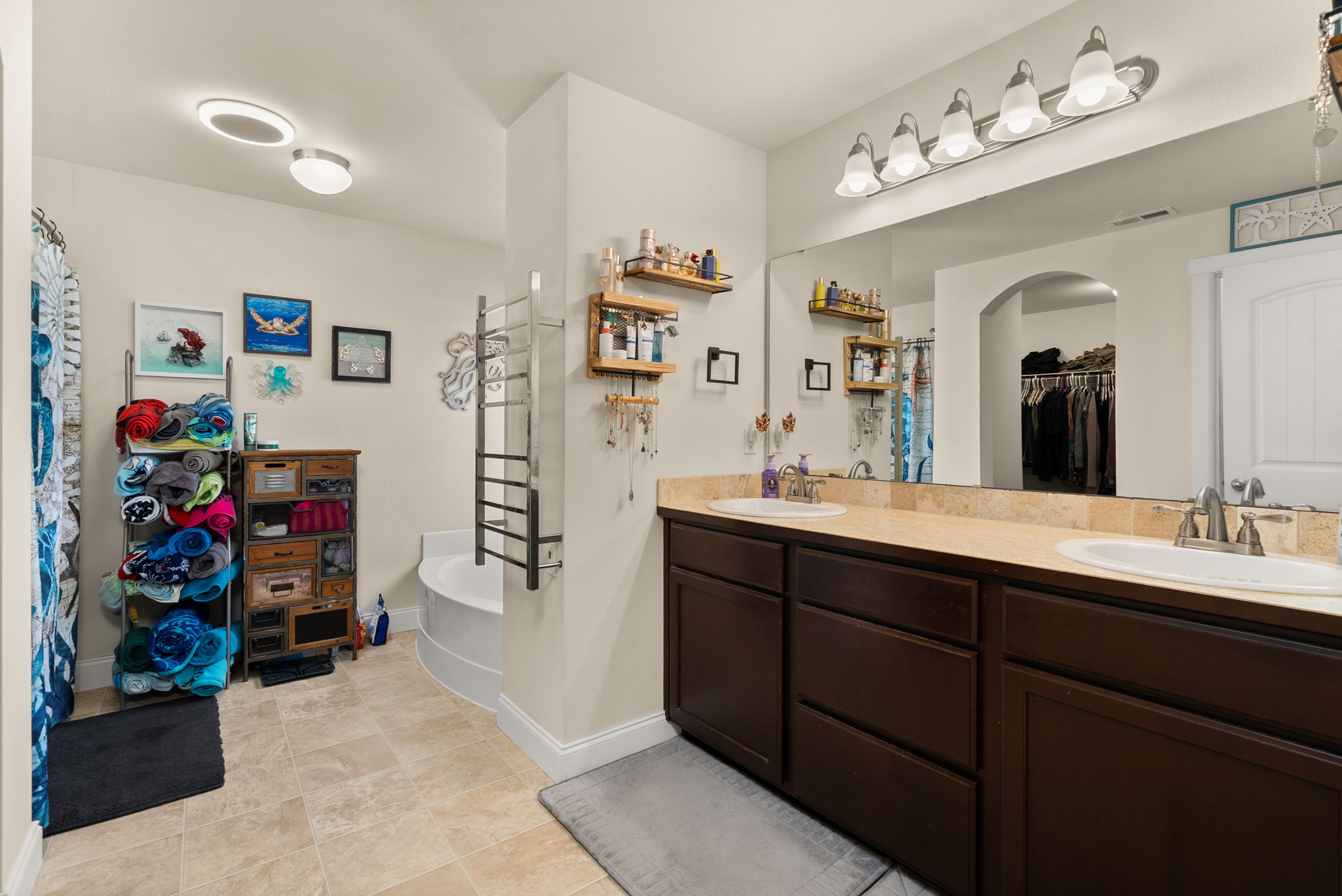 Private 5-piece primary bath with dual vanities, heated towel warmer, Bluetooth bathroom fan and walk-in closet.