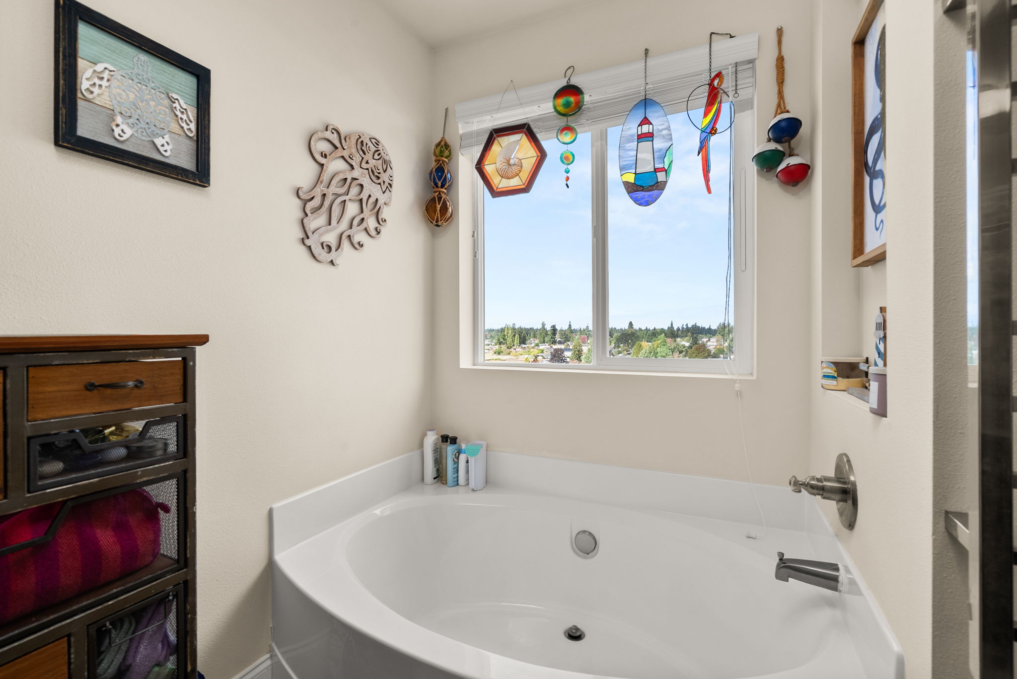 Primary full bath with soaking tub and natural light.