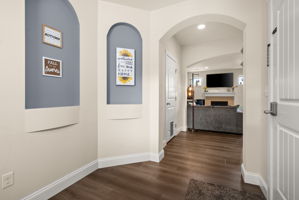 Bright entryway with custom built-in display niches and waterproof luxury vinyl flooring.