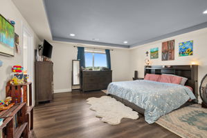 Spacious primary suite with tray ceiling, crown molding and plenty of room for a full bedroom set.