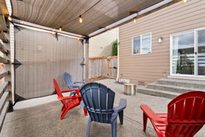 Covered outdoor seating area extends the backyard living space. Bonus as it has been wired for the lighting.