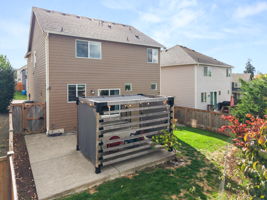 Rear view showcasing the large patio and fully fenced backyard.