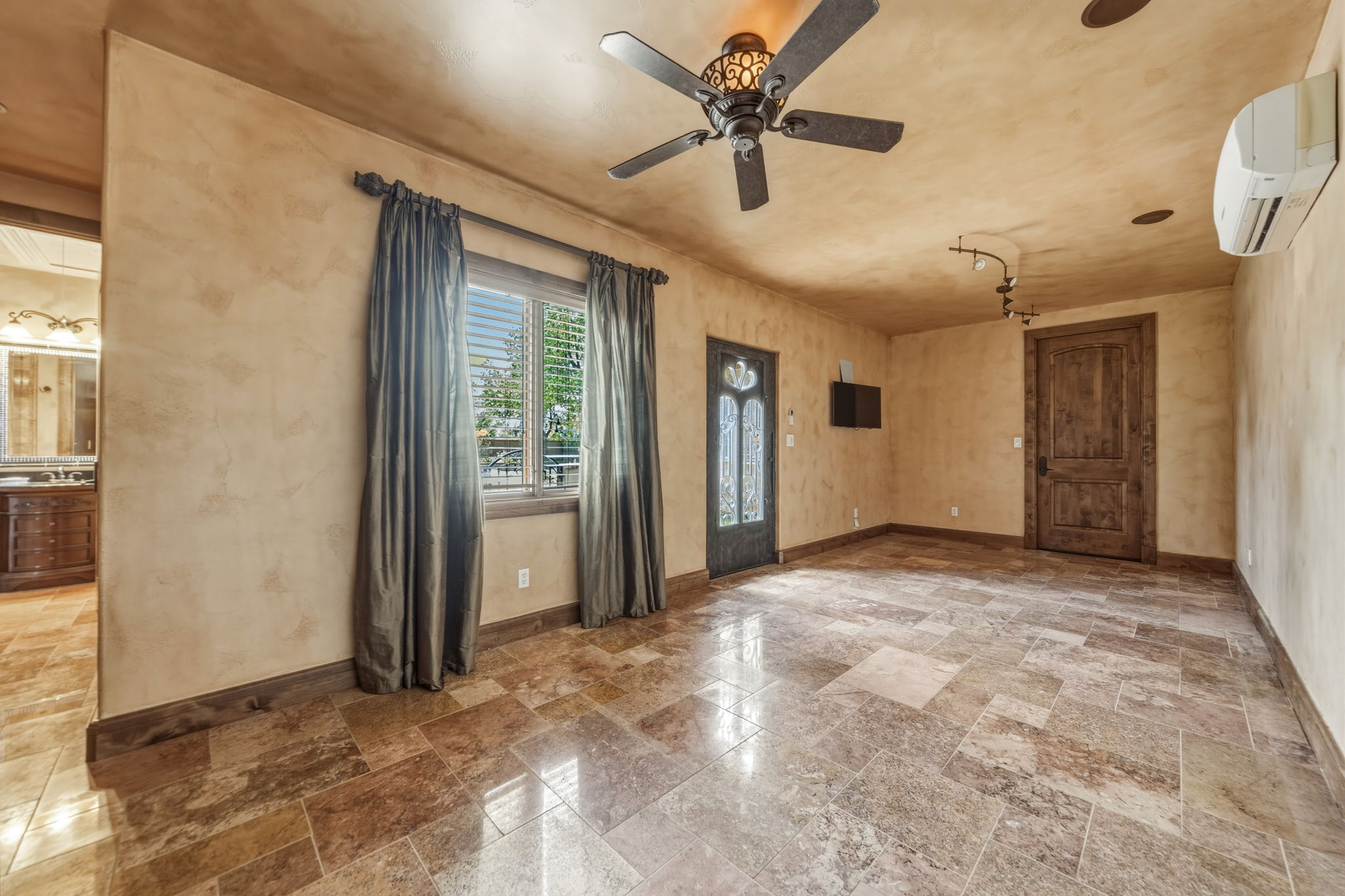 Private entrance from the courtyard or enter through the garage area when it is bad weather.  This property features a spacious room with large format tile flooring, a decorative ceiling fan.